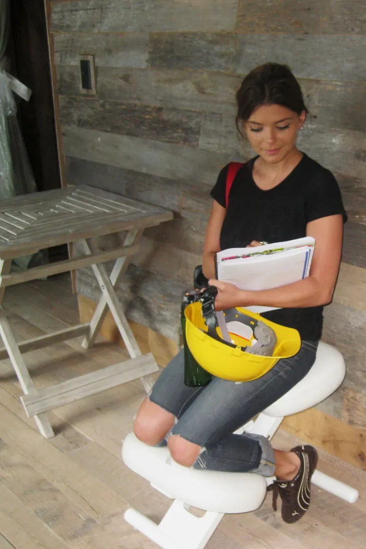 Maria Cooper on site with a hard hat and project notes